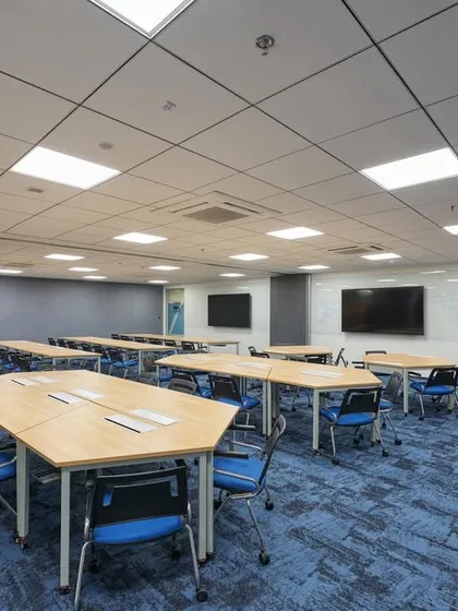 A flexible training room with reconfigurable tables that can be arranged in different layouts for workshops, presentations, or group work.
