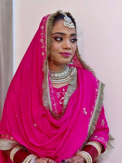 This side profile highlights the flawless draping of the dupatta and the intricate details of the bridal jewelry. The makeup is set perfectly to ensure a shine-free, elegant look throughout the day.