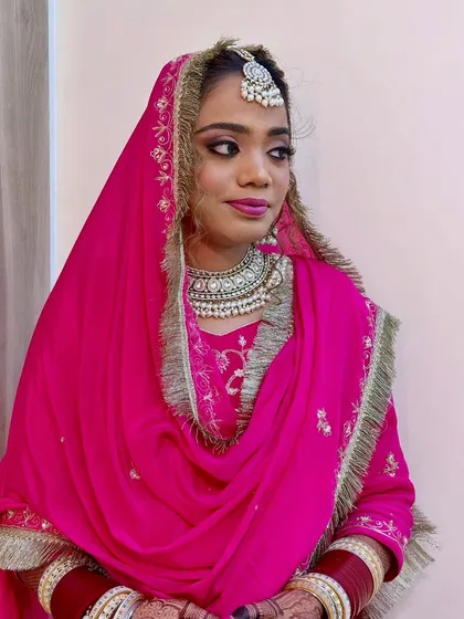 This side profile highlights the flawless draping of the dupatta and the intricate details of the bridal jewelry. The makeup is set perfectly to ensure a shine-free, elegant look throughout the day.