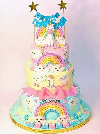 An exquisite three-tier unicorn-themed cake. This magical creation features vibrant pastel colors, edible unicorn figures, and enchanting rainbow details.