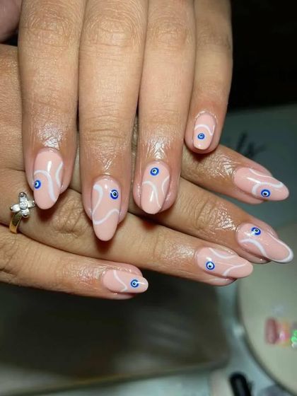 Here is a recreation of an evil eye design a client brought in. I used a nude base with white swirls and carefully placed evil eye details for a modern, artistic look.