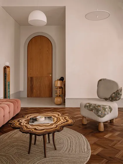 This image captures a collection of our unique seating and table designs. From a plush, channel-tufted sofa to a sculptural lounge chair made of upholstered stone, each piece is designed to be a work of art.