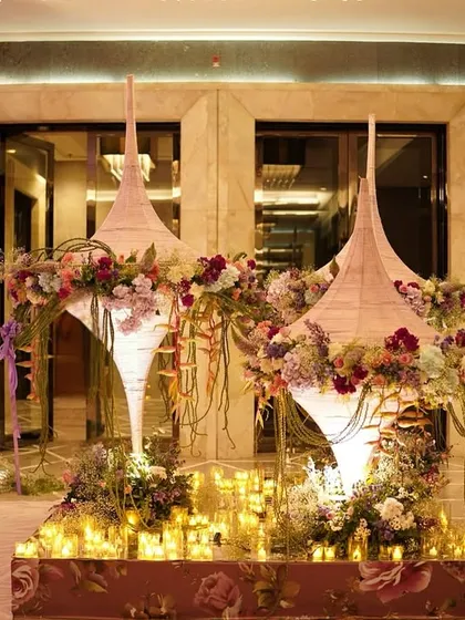 A closer look at the unique welcome installation, with its thread-wrapped cones topped with hydrangeas and a charming wooden welcome board adorned with pearls.