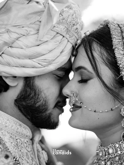 A tight, intimate black and white close-up of the bride and groom, their foreheads touching. This shot strips away all distractions, focusing purely on the deep, quiet connection between two souls.