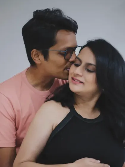 An intimate close-up of the couple at home, capturing a whispered secret or a gentle kiss, showcasing the love between them.