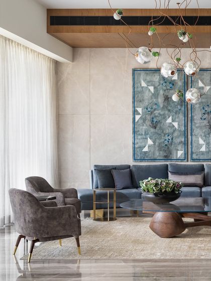The color palette in this K Residence seating area flows from the Kamrooz Aram artwork. The blue of the curved sofa was highly debated but ultimately provides the perfect anchor, while accents of brass in the side tables add a subtle touch of luxury to a quiet space.