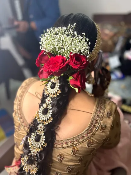 A detailed look at a traditional South Indian bridal hairstyle. I created an intricate braid, beautifully decorated with fresh red roses, baby's breath, and elaborate hair jewellery for a timeless and elegant finish.