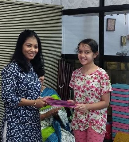 Tanisha Borawankar, an 8th-grade student, receiving her certificate for earning a 'B' grade in the Elementary grade exam. Consistent effort leads to great results.