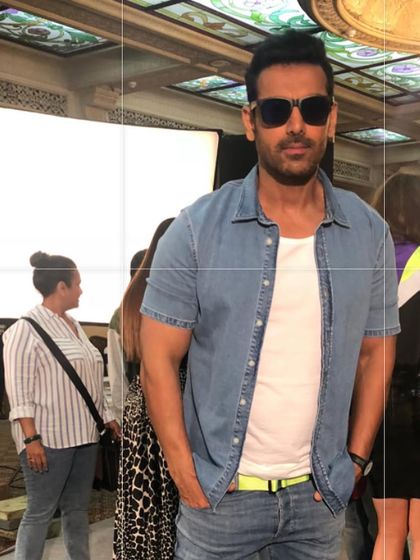 John Abraham looking cool and casual in a denim shirt and sunglasses on a busy set. It's always a collaborative effort with the hair and makeup team.