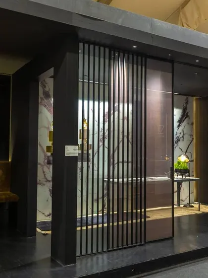 For the JB Glass exhibition booth, we designed a "walk-along" gallery to overcome the challenge of a long, narrow space. This created a unique and highly visible display, with each section framed like a piece of art, showcasing the products in a sophisticated, moody setting.