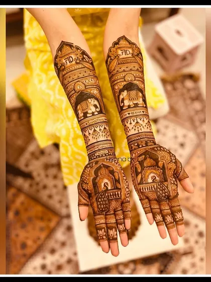 An engagement mehendi that tells a story. This design features the couple's initials, 'TD', along with traditional motifs like elephants and jharokhas for a grand yet personal look.