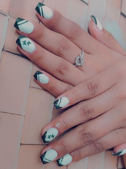 A unique take on a French manicure with black tips, abstract white lines, and tiny butterfly details.