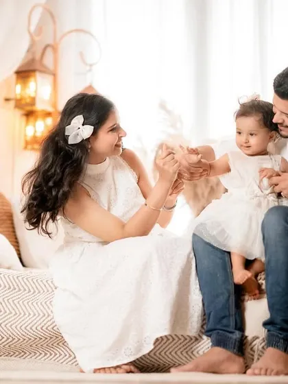 Playful interactions make for the best family photos. This shot captures a fun, candid moment between parents and their daughter in a beautifully styled setting.