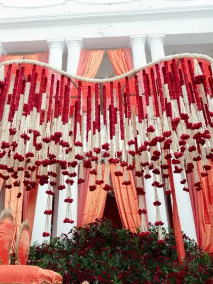 We believe in making a grand first impression. For this wedding, we designed a majestic mandap with cascading strings of red and white flowers, set against the classic architecture of the venue, creating a regal and timeless atmosphere for the ceremony.