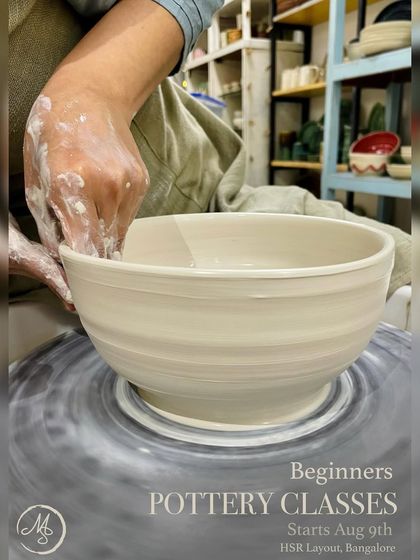 This image captures the dynamic motion of the wheel as a student shapes a large bowl, a key skill taught in our beginner pottery classes.