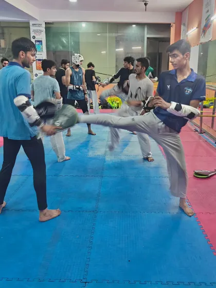 A snapshot of our training floor. An athlete executes a perfect side kick during a partner drill.