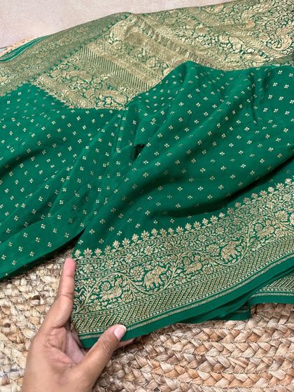 The body of the bottle green saree, showing the delicate butti work and the elegant border with elephant motifs.
