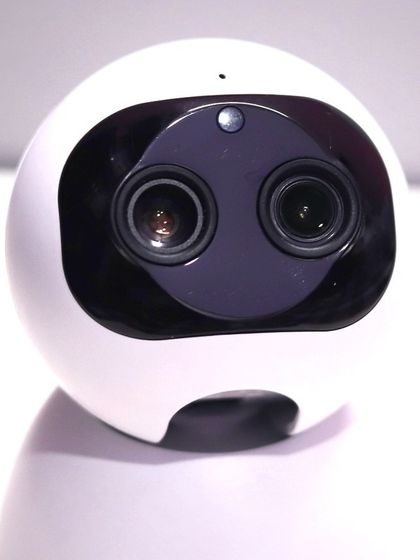 A detailed close-up of the dual lenses on the AI HD IP Camera. This technology allows for enhanced clarity and intelligent tracking features.