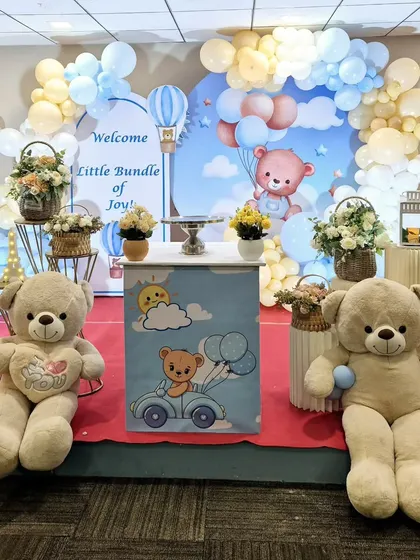A sweet 'Welcome Little Bundle of Joy' baby shower setup with a teddy bear theme and pastel blue and yellow balloons.
