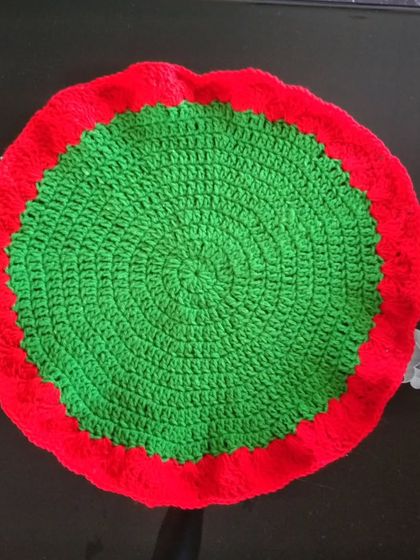 A round table mat in green and red.