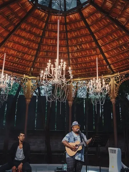 A live band performs under the chandeliers of the Colonial Bandstand during a Sangeet night.