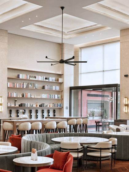 A view of the bar and lounge area at the Elevate Clubhouse. The combination of warm lighting, comfortable seating, and open shelving creates a sophisticated yet relaxed atmosphere for residents.
