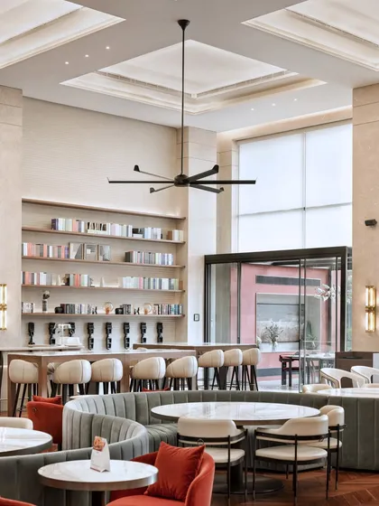 A view of the bar and lounge area at the Elevate Clubhouse. The combination of warm lighting, comfortable seating, and open shelving creates a sophisticated yet relaxed atmosphere for residents.
