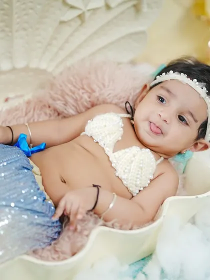 This little mermaid sticks her tongue out playfully, showing off her charming personality.