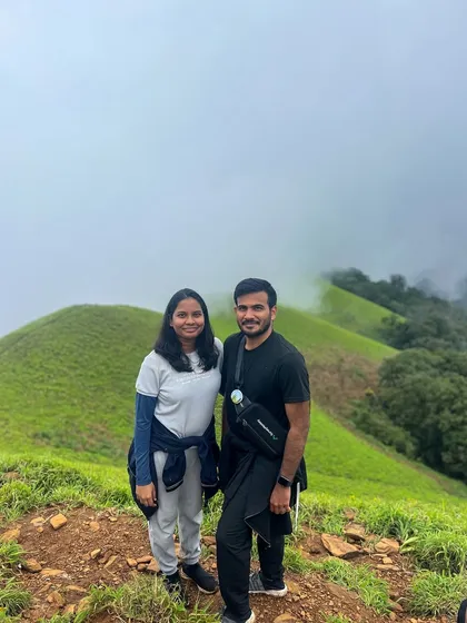 A couple posing together on the Netravathi trail, with the misty green hills creating a romantic backdrop.