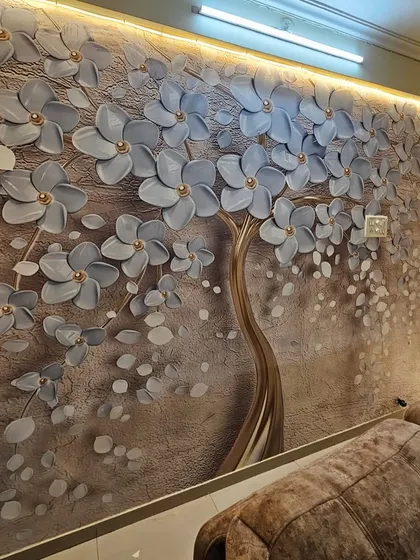A close-up of a completed 3D floral wallpaper installation. The embossed grey flowers with gold centers create a beautiful texture, and the integrated wall lighting highlights the design's depth.