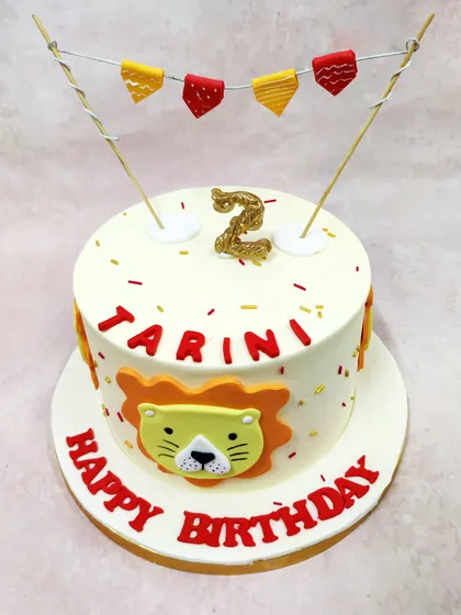 A slightly different view of the lion birthday cake, highlighting the glittery number '2' candle.