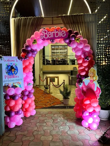 The entrance to the Barbie party, featuring a large balloon arch with a Barbie logo.