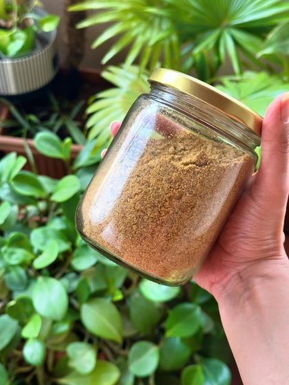 Holding up a jar of my homemade flaxseed pudi, made with roasted flaxseeds, dals, and spices. It's a heart-healthy and gut-friendly recipe.