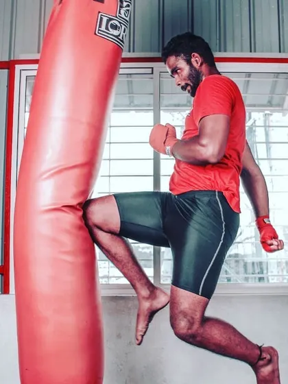 Our kickboxing programs are designed for power and precision. Here, a member executes a powerful knee strike on the heavy bag, a fundamental technique for building core strength and striking ability.