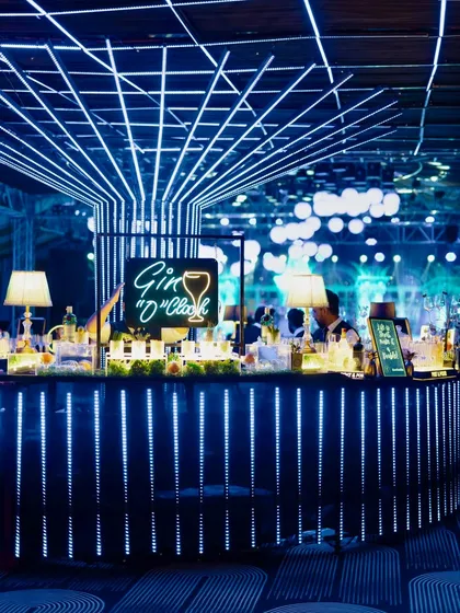 Another view of the futuristic "Gin O'Clock" bar, showcasing the glowing blue LED strips and the grid-like lighting installation on the ceiling.