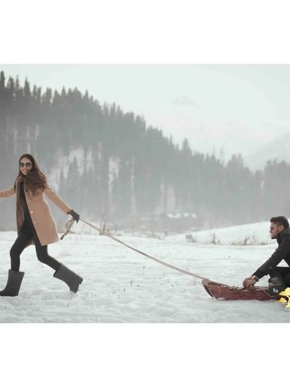 A playful moment with a sled in the snow. This captures the fun and unique experiences we can create during a destination pre-wedding shoot in Kashmir.