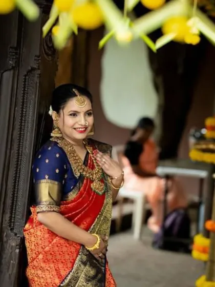 A happy moment captured during the wedding festivities. Apoorva's red and blue Kanchipuram silk saree shines, reflecting the joy of the occasion.