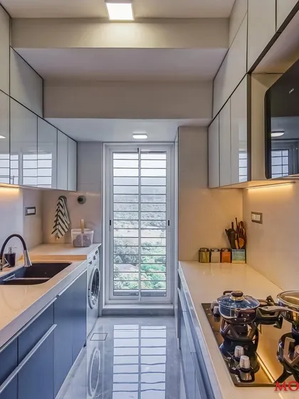 A parallel kitchen design that combines white upper cabinets with blue lower cabinets, creating a striking contrast. This space includes a dedicated spot for a washing machine, showing our focus on practical solutions.