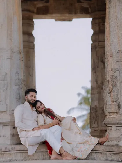 An intimate and tender moment between the couple, framed by the temple's stone pillars. This photo focuses on the emotional connection and quiet anticipation of parenthood.