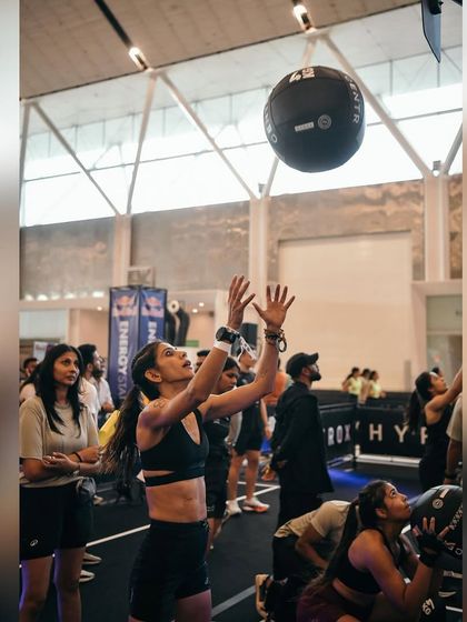 Wall balls at a HYROX event. This exercise is a test of lower body power, core stability, and shoulder endurance. We practice this to ensure you can handle the toughest final stations of any race.