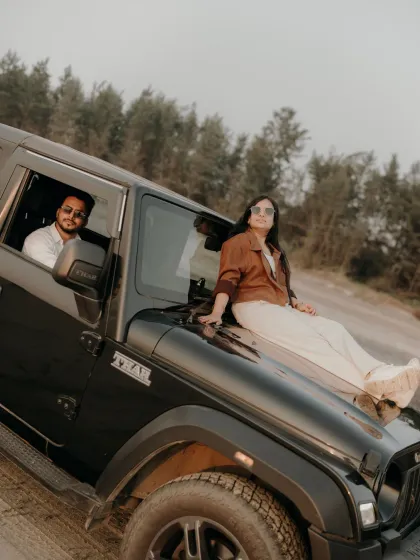 Relaxing on their Mahindra Thar, enjoying the view. This shot combines their love for adventure with a cool, laid-back vibe.
