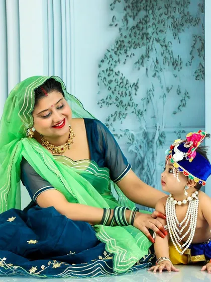 Another beautiful moment from our Janmashtami session. The mother, dressed in a lovely green and blue outfit, lovingly gazes at her son in his adorable Krishna costume, creating a cherished memory of this cultural celebration.