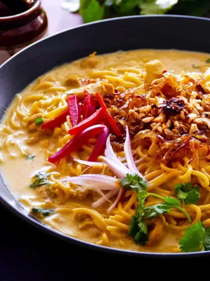 A comforting bowl of Burmese Khowsuey, with rich coconut curry broth, noodles, and an array of crunchy and fresh toppings. This can be served as a main course or in smaller portions as an appetizer.