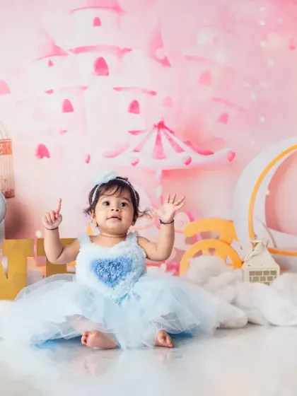 This little princess is one year old. The magical pink castle backdrop and whimsical props make for an enchanting first birthday portrait.