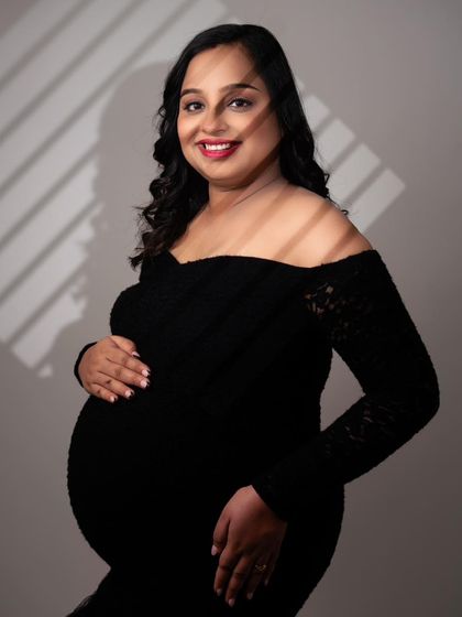 Playing with light and shadow can create a dramatic, artistic effect. The gentle light from the blinds adds texture and mood to this beautiful maternity portrait, highlighting her features and the baby bump.