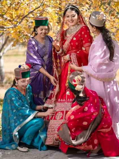 The bride with her bridesmaids, all dressed in traditional Kinnauri outfits, helping her get ready for the ceremony.