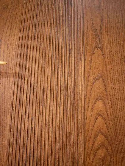 A close-up of the fluted texture on a natural wood veneer door. You can see the depth of the grooves and the natural variation in the wood grain.