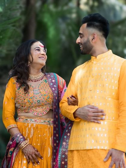 A lovely candid of the couple walking together in vibrant yellow outfits. Their relaxed posture and happy expressions make for a beautiful pre-wedding photo.