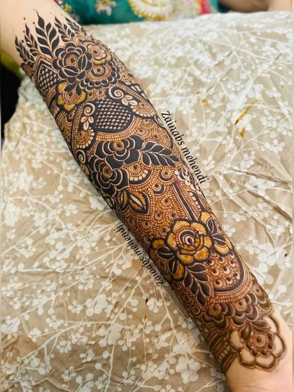 A detailed shot of the forearm, showing the transition from floral motifs to patterned bands.