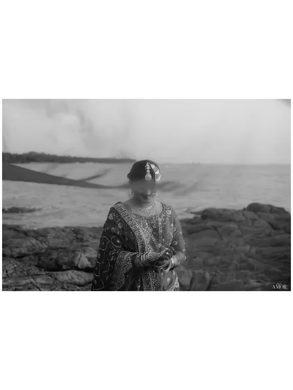 An artistic, hazy black and white portrait of the bride by the sea. The soft focus and monochrome treatment give this image a dreamy, ethereal quality.